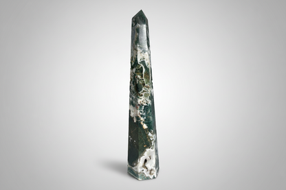 Tall, green crystal obelisk on a white background